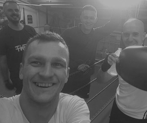 Our coach Andrzej taking selfie right after a good treining session. He is standing at the ring, surrounded by our adepts. They are all smiling.